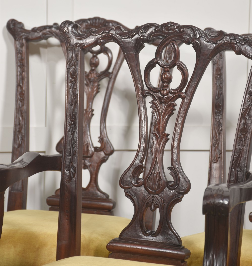 A set of eight dark mahogany dining chairs featuring elaborate pierced back splats, cabriole legs with ball and claw feet, and mustard yellow velvet upholstered seats. View V