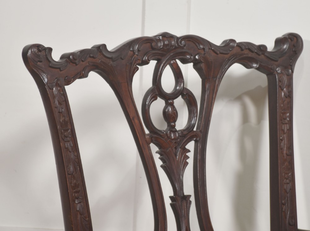 A set of eight dark mahogany dining chairs featuring elaborate pierced back splats, cabriole legs with ball and claw feet, and mustard yellow velvet upholstered seats. View VIII