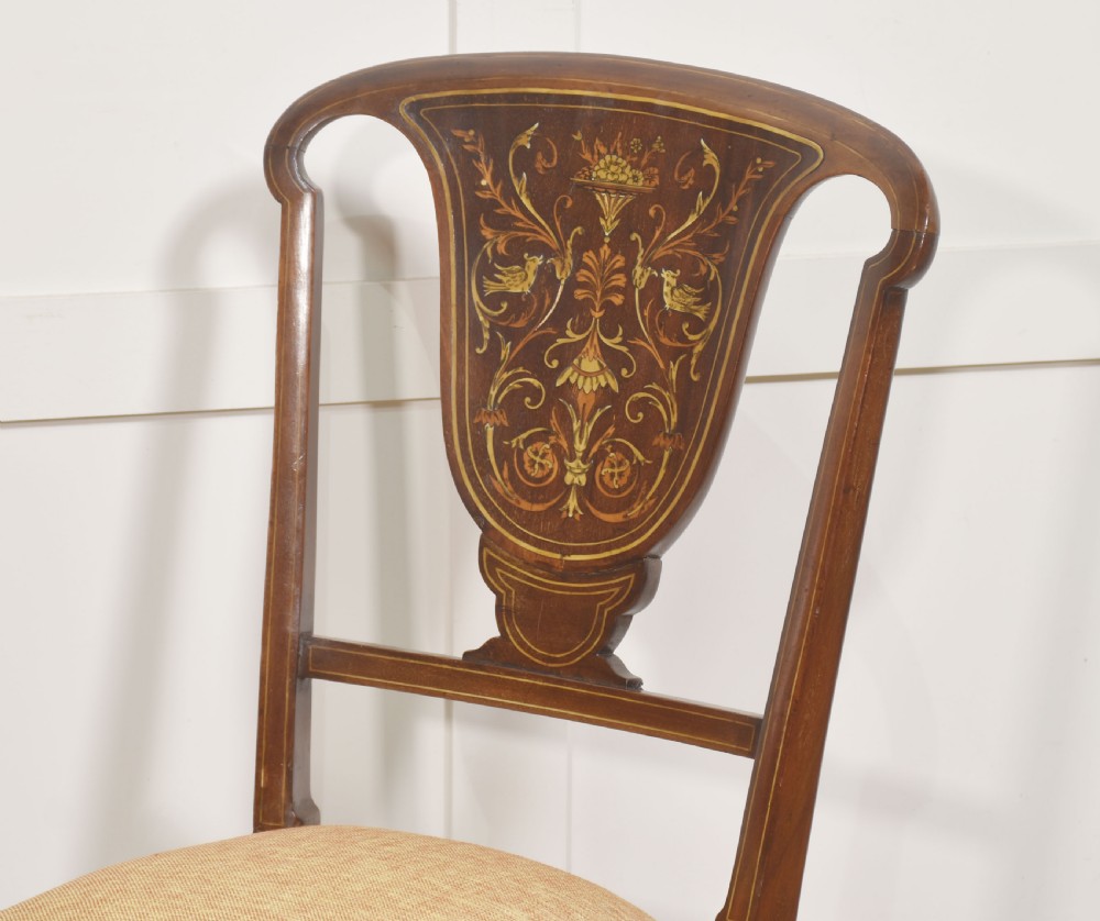 A pair of Edwardian inlaid mahogany side chairs with vase-shaped marquetry splats, cabriole front legs, and golden upholstered seats. View V
