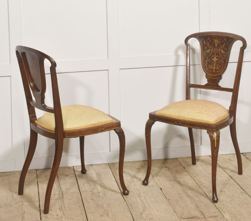 A pair of Edwardian inlaid mahogany side chairs with vase-shaped marquetry splats, cabriole front legs, and golden upholstered seats. View VIII
