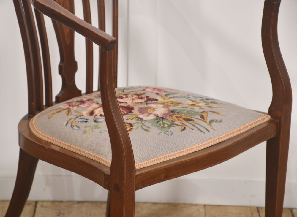 An Edwardian mahogany occasional armchair with satinwood stringing inlay, curved arms, vertical back spindles, and a floral needlepoint upholstered seat. View VII