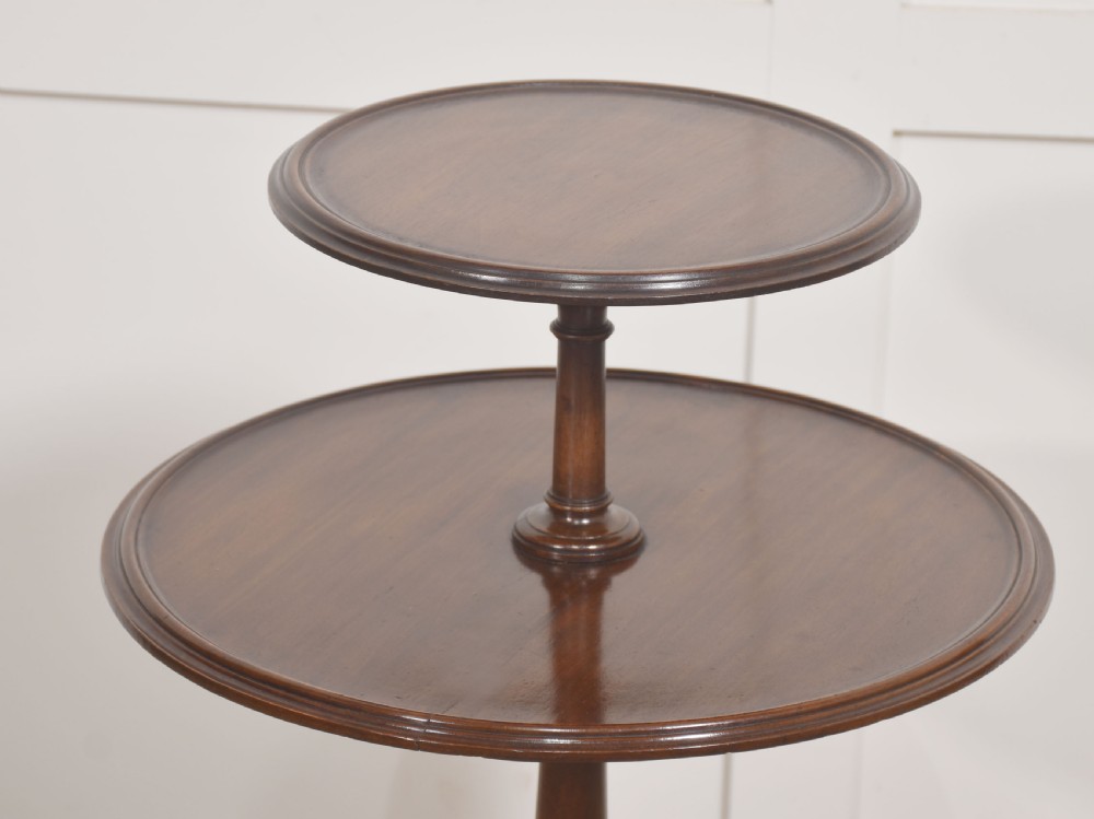 A George III style mahogany two-tier side table featuring graduated circular tops, a turned central column, and carved tripod legs. View IV
