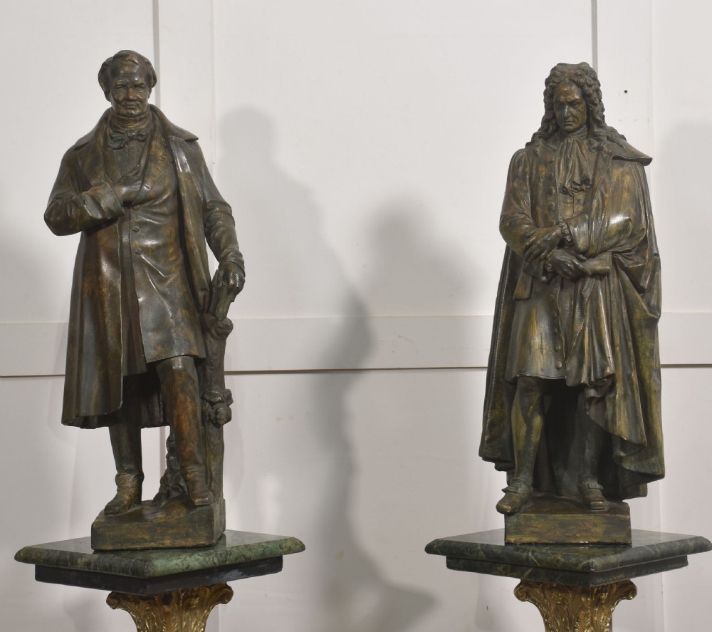 A pair of late nineteenth-century patinated chalkware statues depicting two standing male figures in historical attire on integral rectangular bases. View VII
