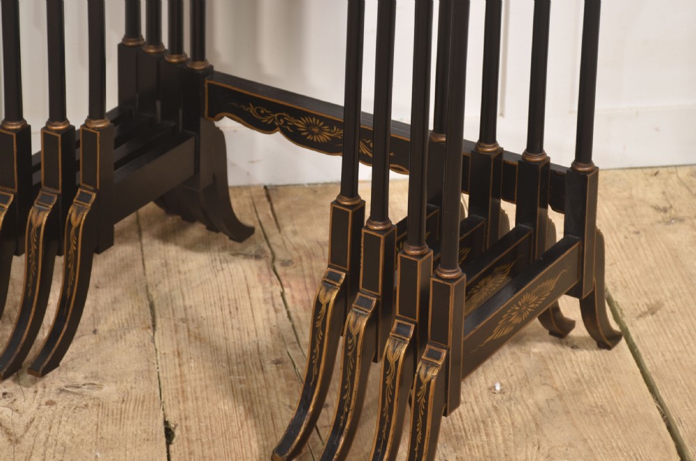 A graduating set of four black lacquered nesting tables decorated with gold Chinoiserie landscapes, slender turned legs, and curved stretchers. View III