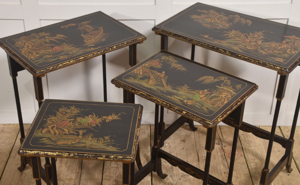 A graduating set of four black lacquered nesting tables decorated with gold Chinoiserie landscapes, slender turned legs, and curved stretchers. View VIII