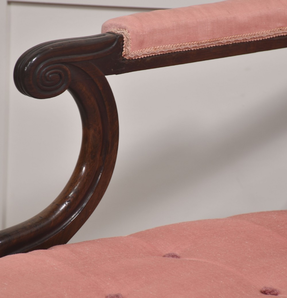 A William IV rosewood chaise longue upholstered in pink fabric with a matching bolster cushion and turned legs on brass castors. View III