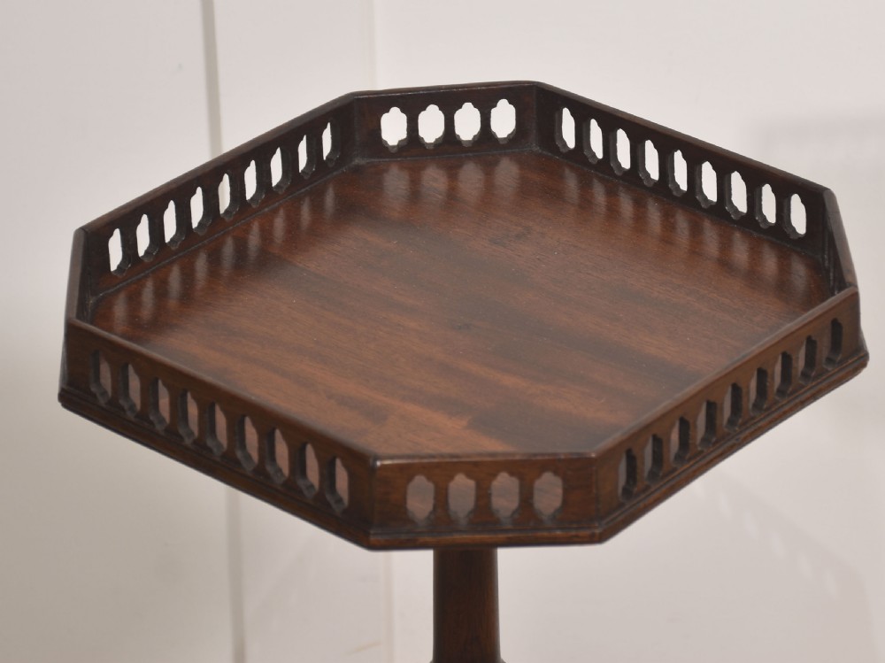 A dark mahogany occasional wine table featuring a pierced fretwork gallery top set on a turned tripod pedestal base. View II