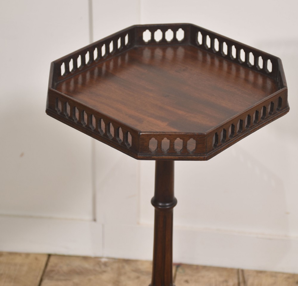 A dark mahogany occasional wine table featuring a pierced fretwork gallery top set on a turned tripod pedestal base. View VI