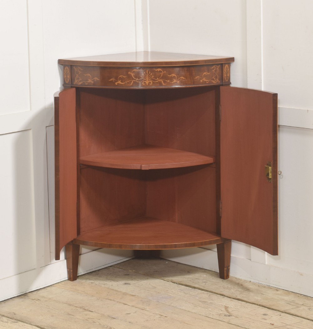 A floor-standing Sheraton Revival bow-front mahogany corner cabinet with satinwood neoclassical urn marquetry on twin doors. View II