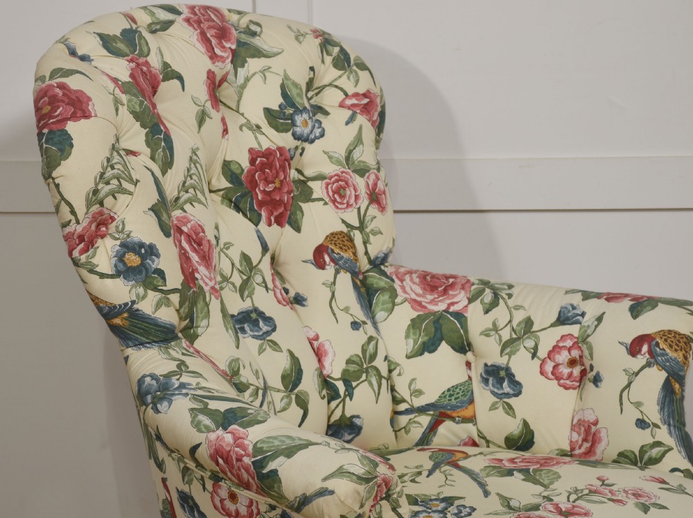 A late nineteenth-century Victorian armchair upholstered in cream floral and bird patterned fabric featuring a button-backed backrest and a pleated bottom skirt. View IV