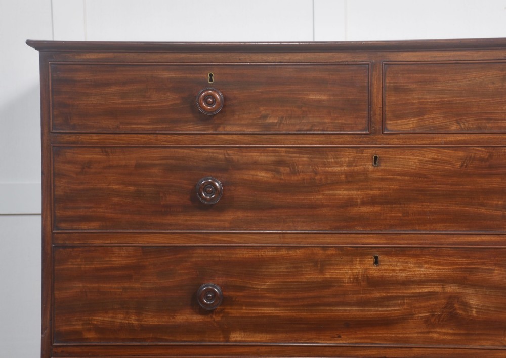 A tall antique mahogany chest of drawers featuring two short upper drawers over five long lower drawers with turned wooden knobs and bun feet. View VIII
