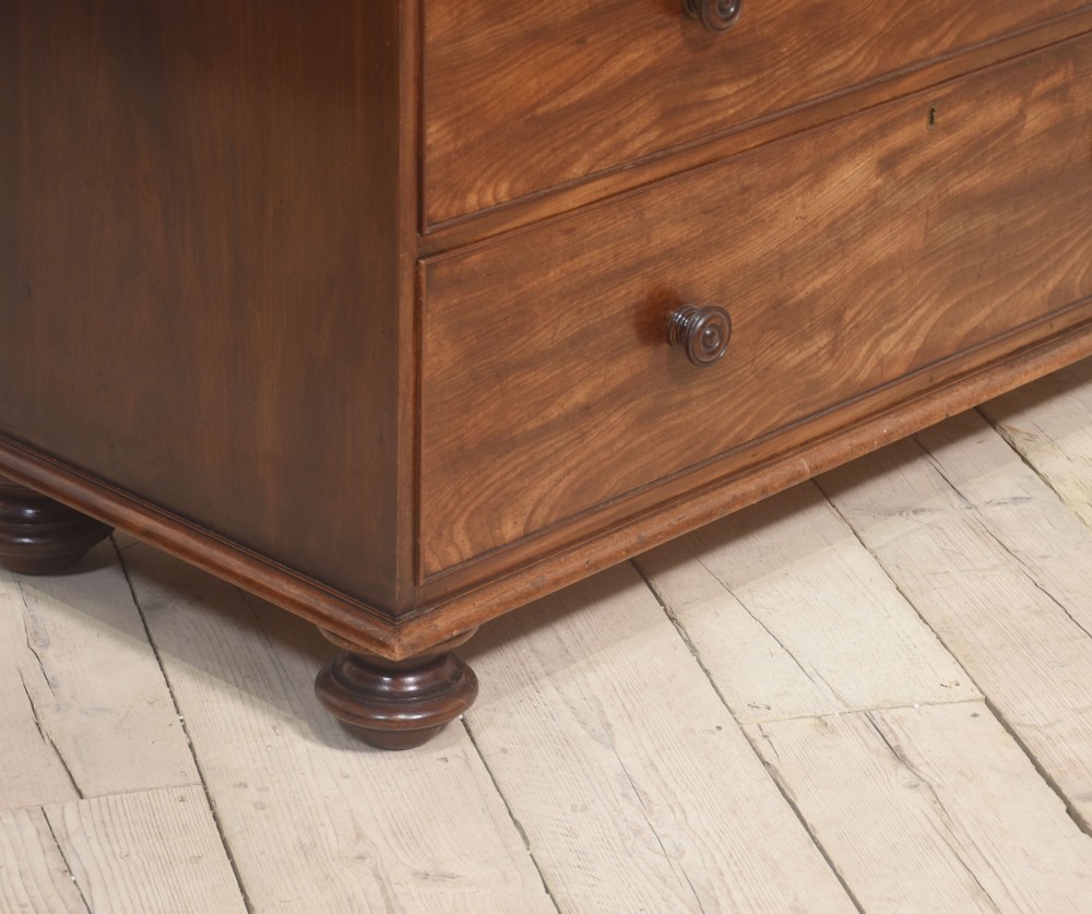 A tall antique mahogany chest of drawers featuring two short upper drawers over five long lower drawers with turned wooden knobs and bun feet. View IX