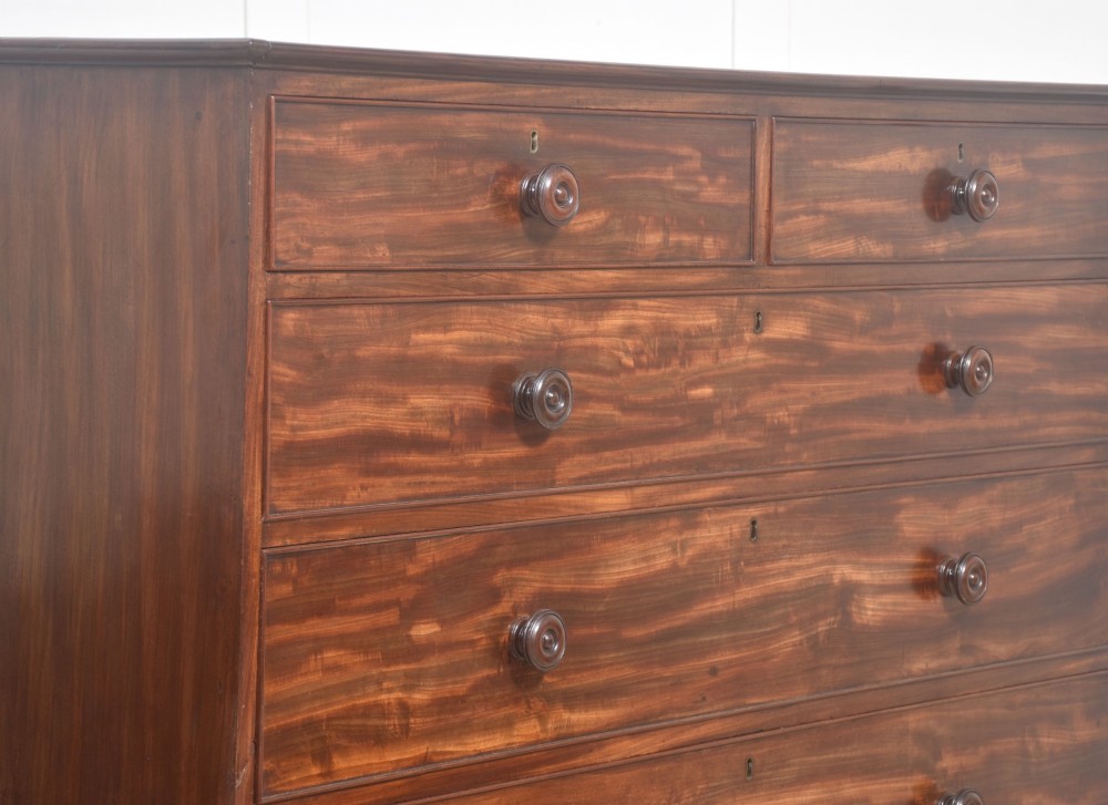 A tall antique mahogany chest of drawers featuring two short upper drawers over five long lower drawers with turned wooden knobs and bun feet. View X