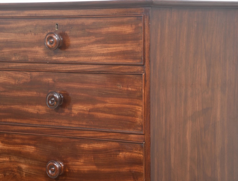 A tall antique mahogany chest of drawers featuring two short upper drawers over five long lower drawers with turned wooden knobs and bun feet. View XI