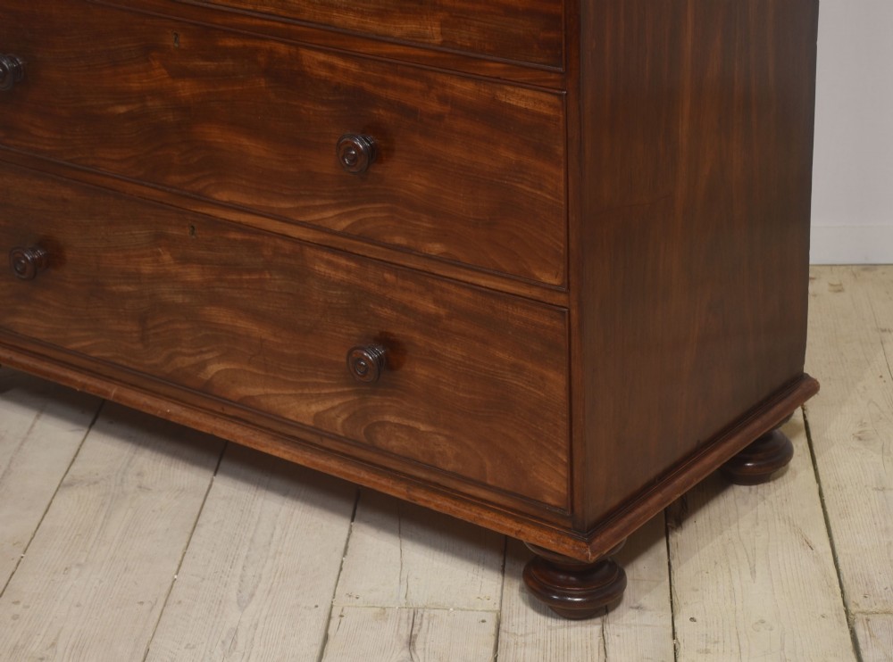 A tall antique mahogany chest of drawers featuring two short upper drawers over five long lower drawers with turned wooden knobs and bun feet. View XII