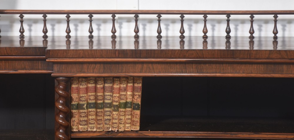 A large Victorian rosewood breakfront open bookcase featuring three shelf sections, carved barley twist columns, and a spindle gallery along the top edge. View XIII
