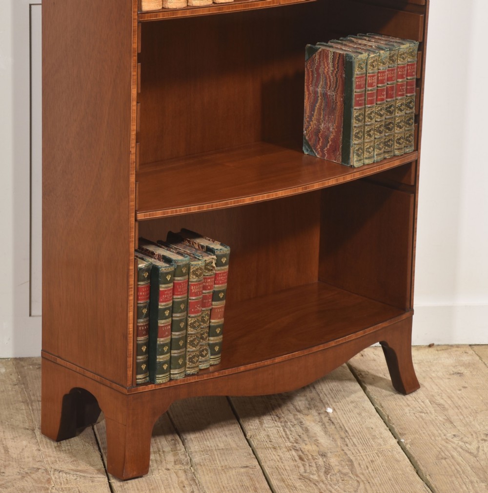 A tall, narrow mahogany open bookcase featuring five shelves, decorative inlay on the top frieze, and shaped bracket feet. View IV