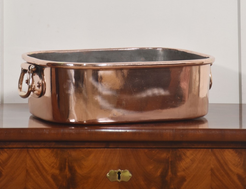 A deep rectangular antique copper fish kettle featuring heavy riveted brass drop handles and a tin-lined interior.