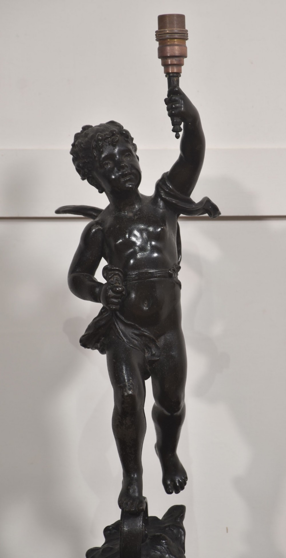 A 19th-century patinated dark bronze table lamp crafted in the shape of a standing cherub holding a torch socket on a moulded base. View III