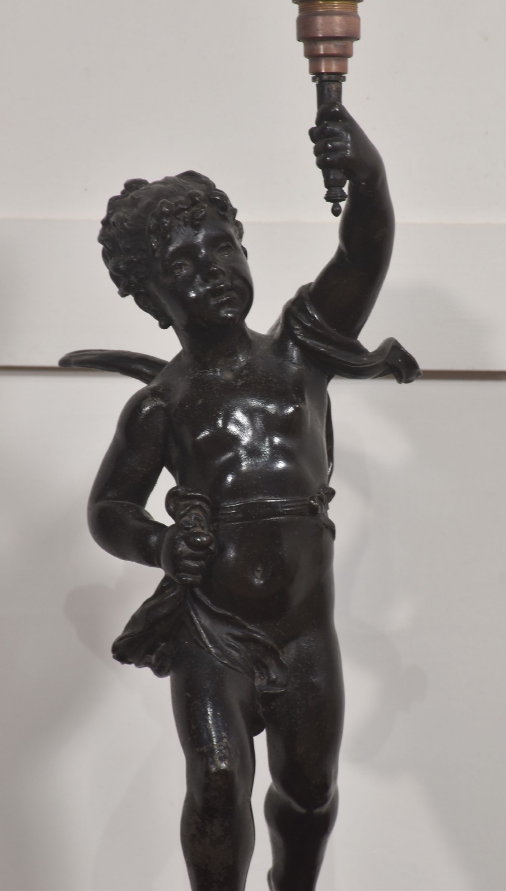 A 19th-century patinated dark bronze table lamp crafted in the shape of a standing cherub holding a torch socket on a moulded base. View IV