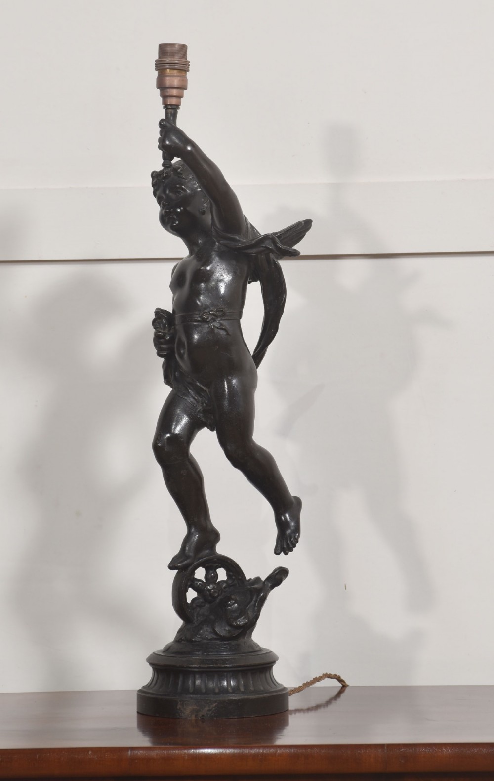 A 19th-century patinated dark bronze table lamp crafted in the shape of a standing cherub holding a torch socket on a moulded base. View V