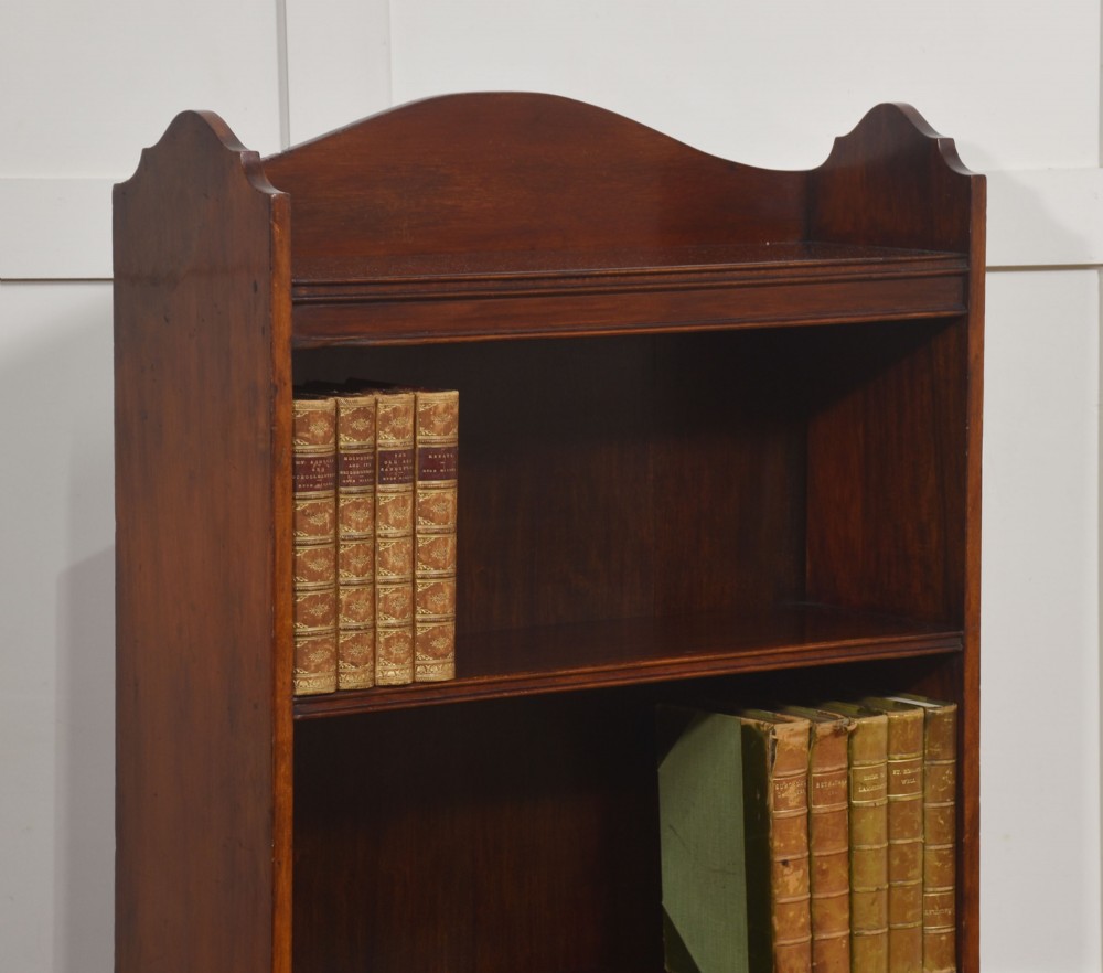 A tall Georgian style mahogany open bookcase featuring three open shelves, a contoured upper gallery, and a lower two-door panelled cupboard raised on bracket feet. View V