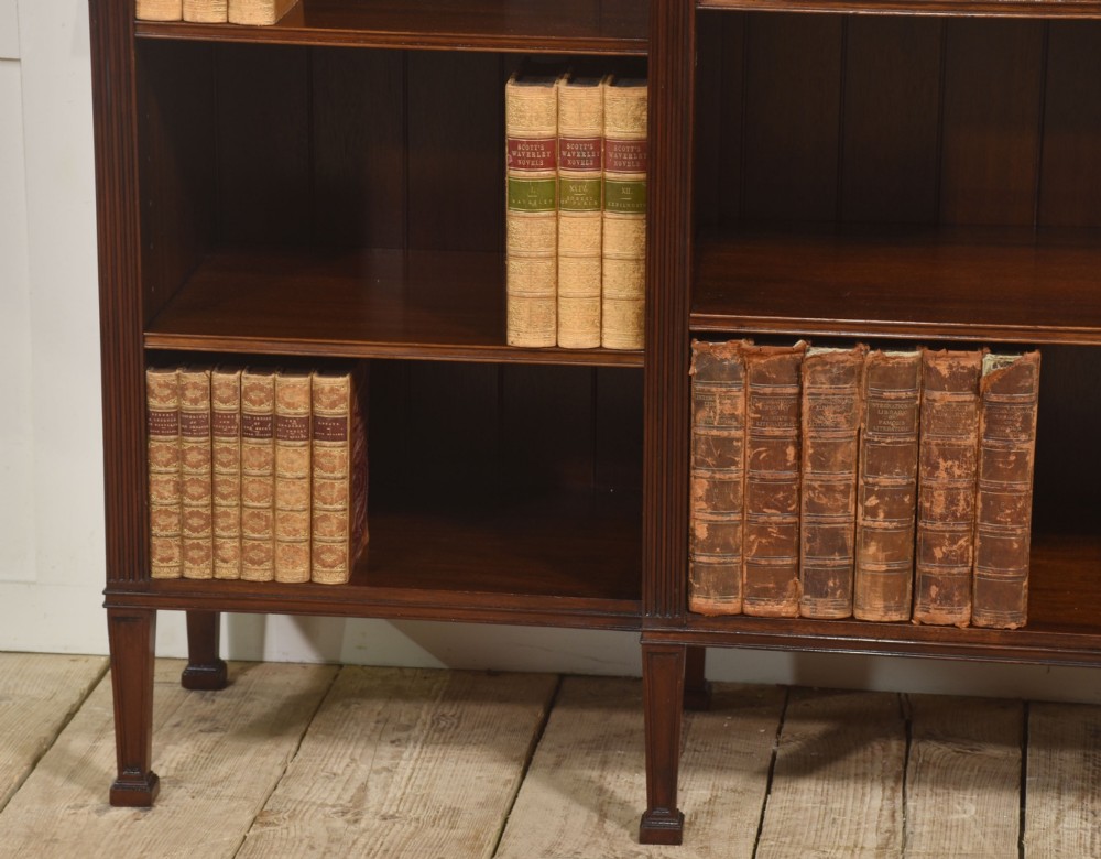 A low flame mahogany breakfront open bookcase featuring fluted pilasters, carved patera rosettes, and three open shelving sections. View III