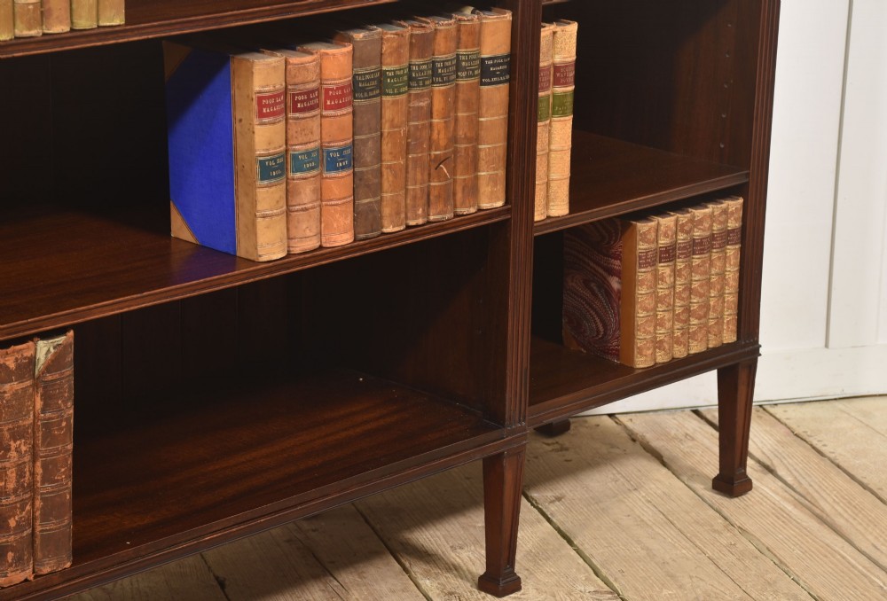 A low flame mahogany breakfront open bookcase featuring fluted pilasters, carved patera rosettes, and three open shelving sections. View VI