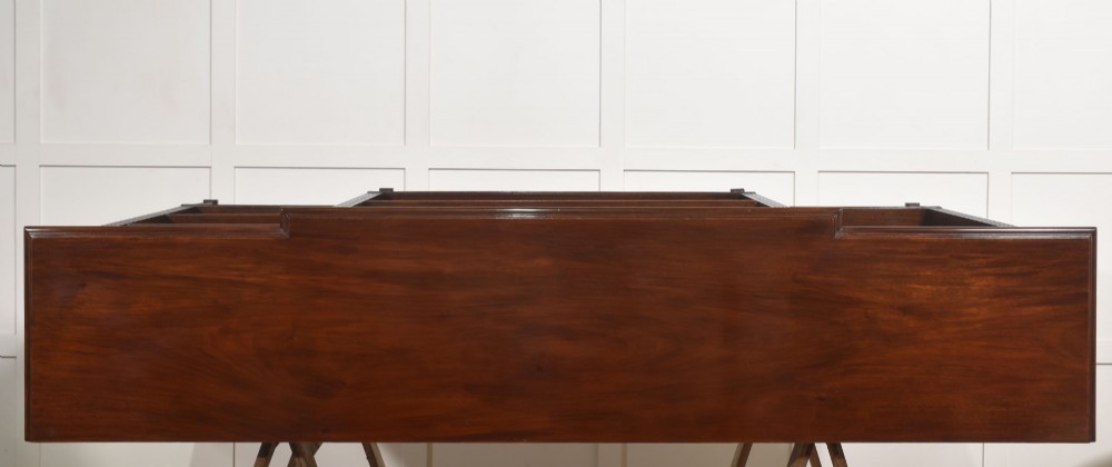 A low flame mahogany breakfront open bookcase featuring fluted pilasters, carved patera rosettes, and three open shelving sections. View XII