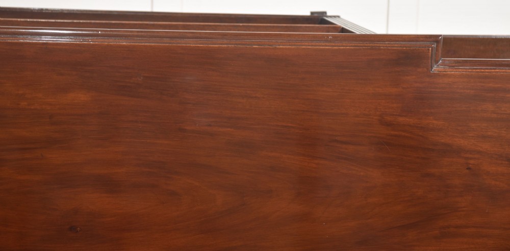 A low flame mahogany breakfront open bookcase featuring fluted pilasters, carved patera rosettes, and three open shelving sections. View XIII