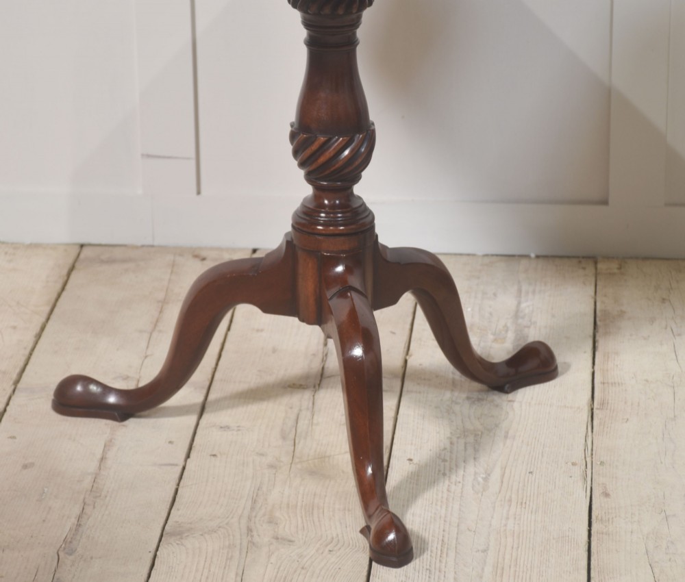 A matching pair of octagonal mahogany tripod tables featuring central starburst marquetry inlays, spiral twist turned columns, and three cabriole legs. View IX