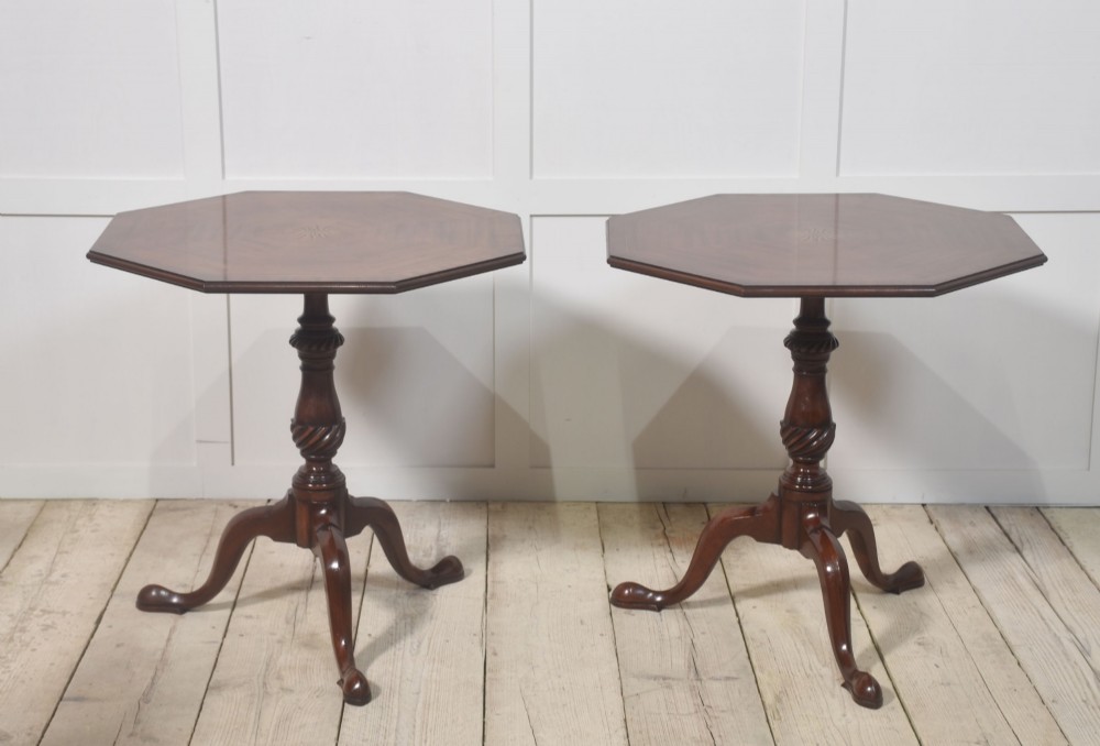 A matching pair of octagonal mahogany tripod tables featuring central starburst marquetry inlays, spiral twist turned columns, and three cabriole legs. View X