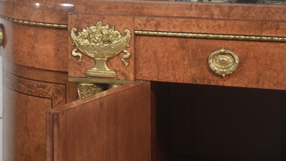 A French bow-front buffet sideboard featuring a dark marble top, burr walnut marquetry, central figural medallions, and flanking marble columns with gilt mounts. View VIII