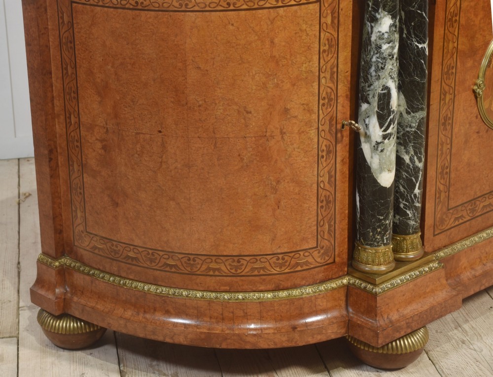 A French bow-front buffet sideboard featuring a dark marble top, burr walnut marquetry, central figural medallions, and flanking marble columns with gilt mounts. View XIII