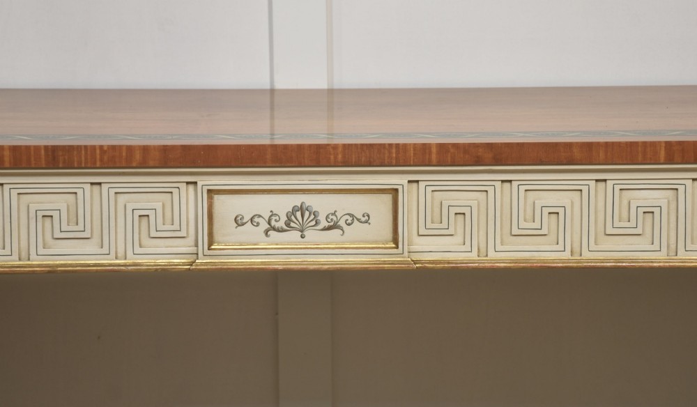 A long Neoclassical style console table featuring a polished timber top with an inlaid border, an off-white apron decorated with a painted Greek key pattern, and carved scroll legs with gilt detailing. View VIII