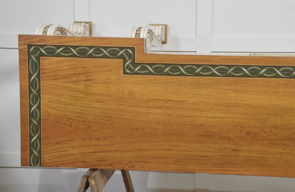 A long Neoclassical style console table featuring a polished timber top with an inlaid border, an off-white apron decorated with a painted Greek key pattern, and carved scroll legs with gilt detailing. View XIII