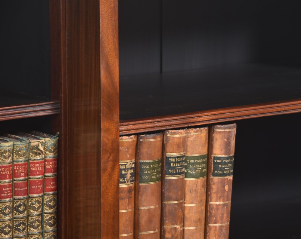 A large mahogany breakfront open library bookcase featuring multiple shelves, a fluted frieze with carved medallions, and sturdy bracket feet. View VIII