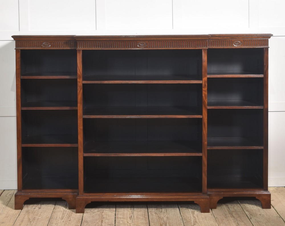 A large mahogany breakfront open library bookcase featuring multiple shelves, a fluted frieze with carved medallions, and sturdy bracket feet. View IX