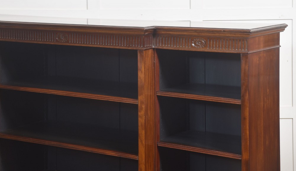 A large mahogany breakfront open library bookcase featuring multiple shelves, a fluted frieze with carved medallions, and sturdy bracket feet. View XIII