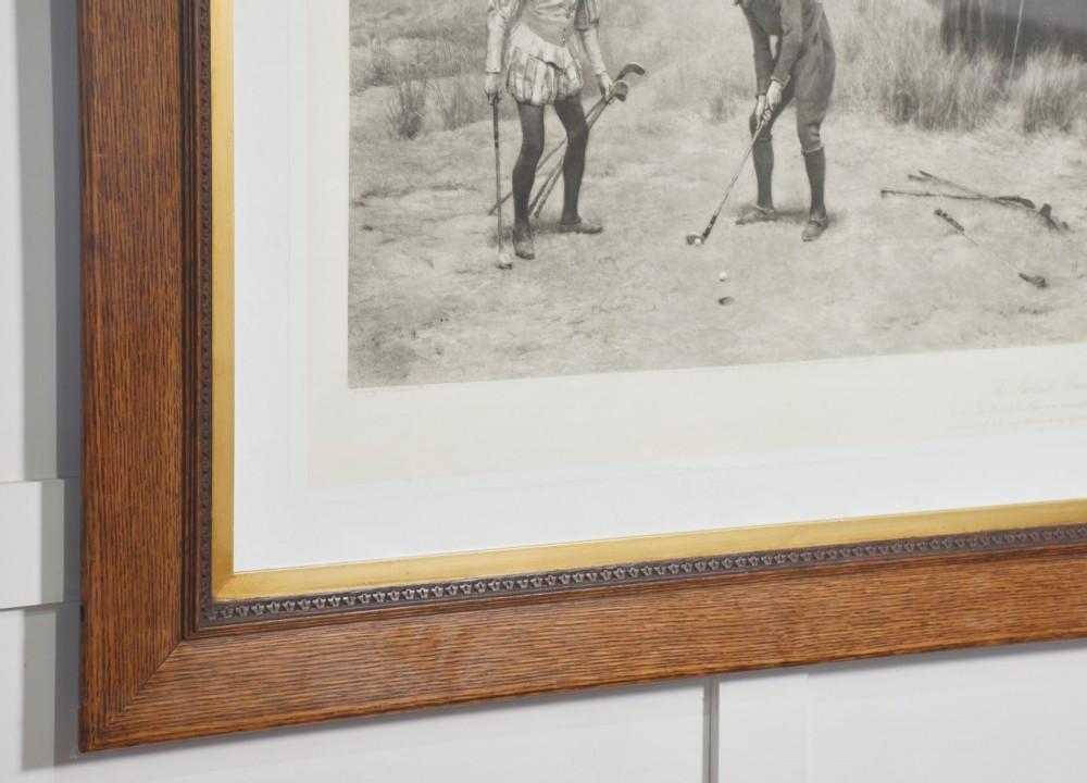 A large monochrome Victorian narrative print depicting golf players on coastal dunes being observed by clergymen, framed in quarter-sawn oak with a gilt inner slip. View VIII