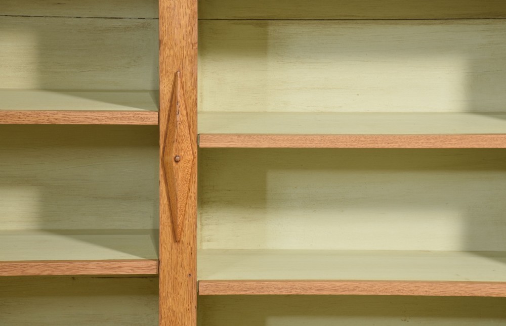 A large 19th-century oak open bookcase featuring three bays, carved decorative corbels, adjustable shelves, and a pale green painted interior. View VIII
