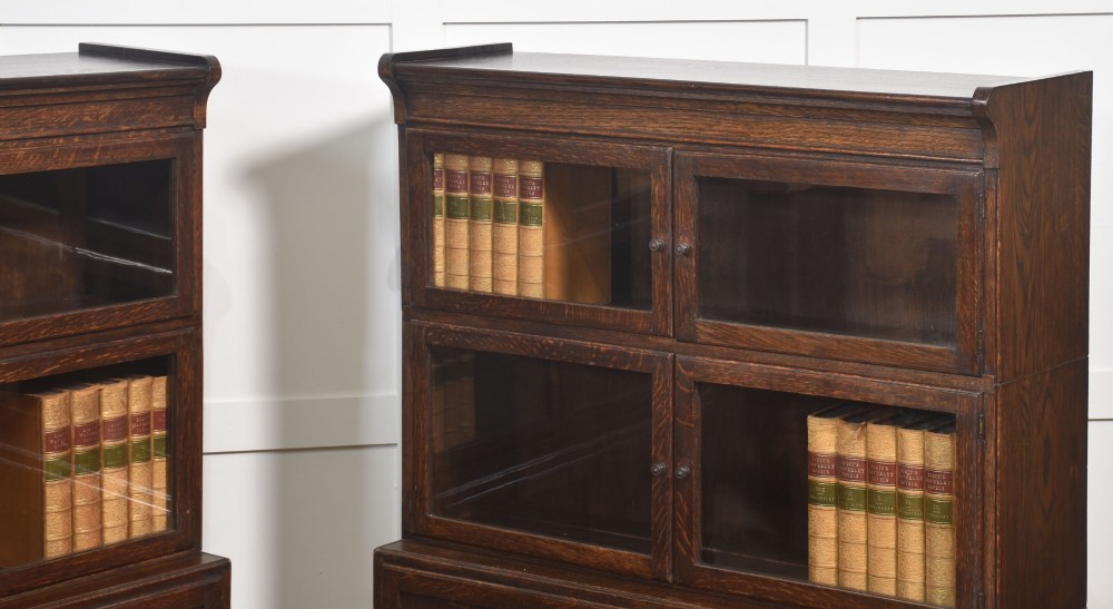 A pair of early twentieth-century dark oak sectional bookcases featuring two glazed upper tiers and a double-door base cupboard on turned feet. View III