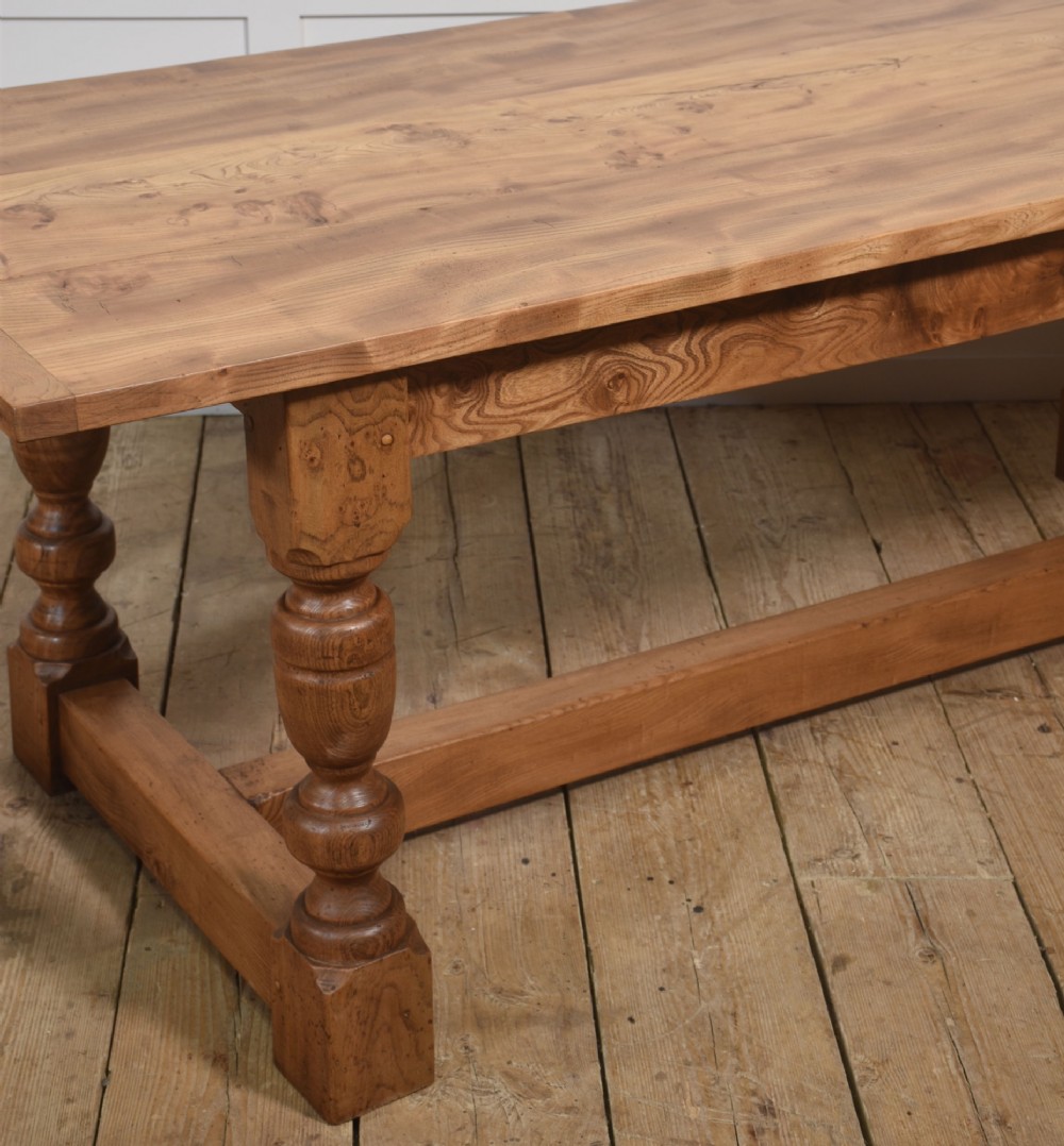 A 19th-century rectangular elm refectory dining table featuring turned wooden legs connected by a central lower stretcher. View III