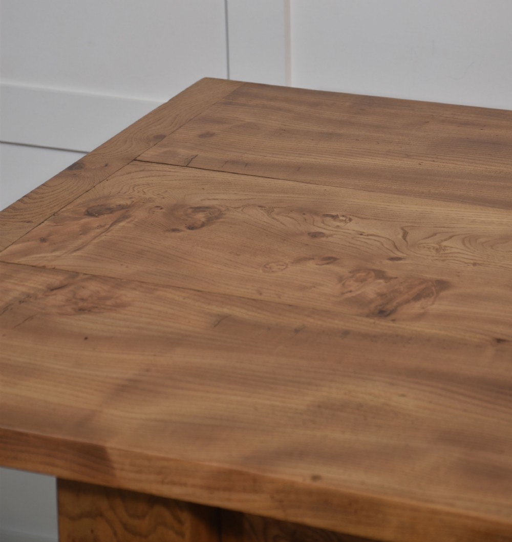 A 19th-century rectangular elm refectory dining table featuring turned wooden legs connected by a central lower stretcher. View VI