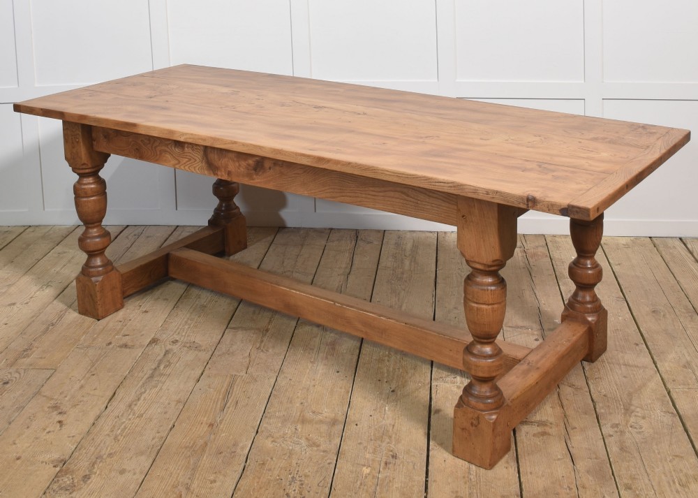 A 19th-century rectangular elm refectory dining table featuring turned wooden legs connected by a central lower stretcher. View VIII
