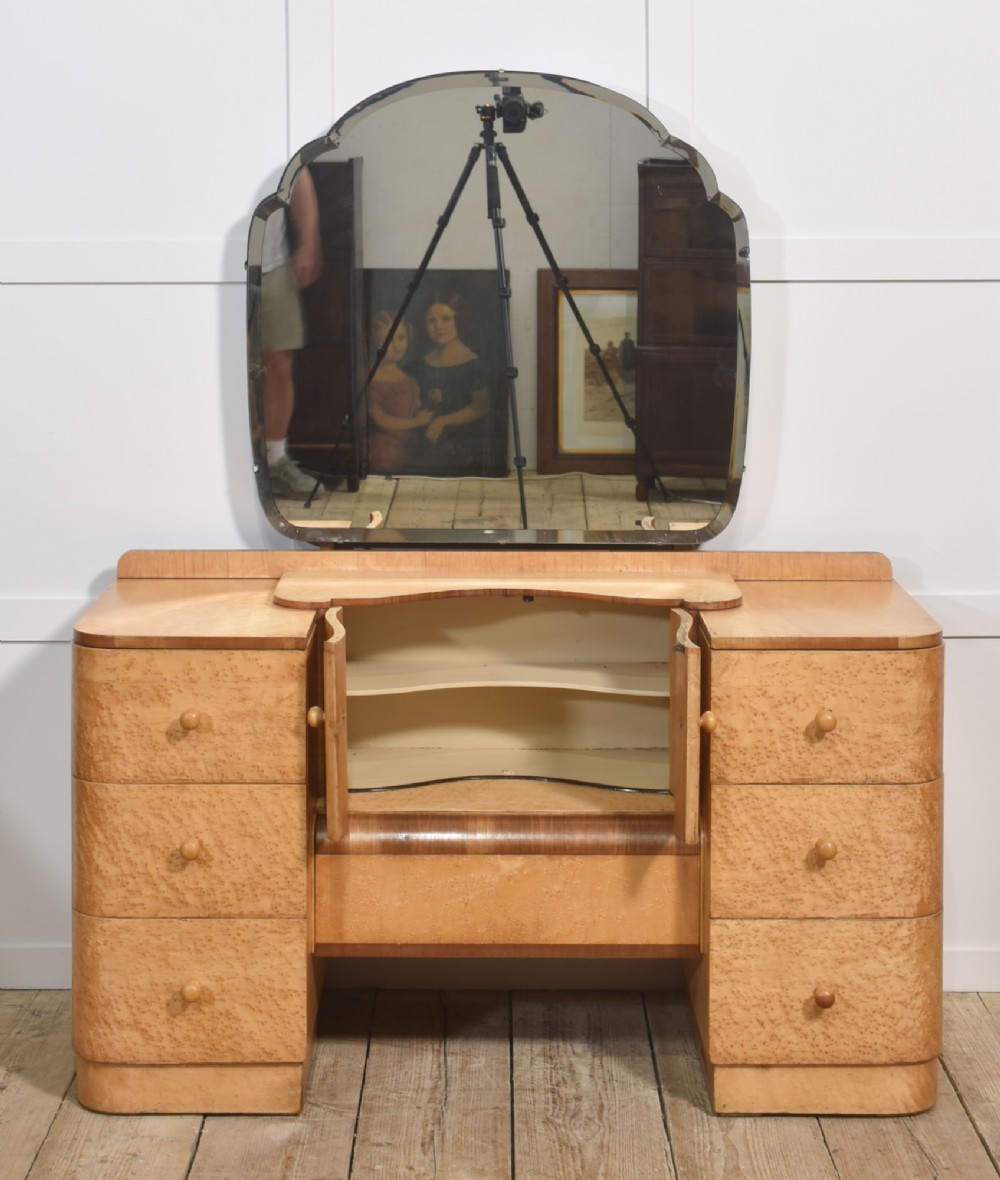 An Art Deco light blonde birds eye maple dressing table featuring curved pedestal drawers, a central cupboard, and a large shaped mirror attached above. View III