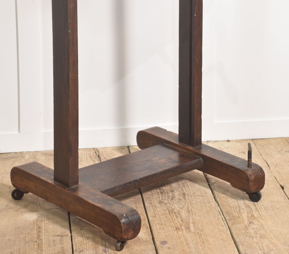 A nineteenth-century dark oak artist studio easel featuring a winding crank handle mechanism and castors on the base. View VI