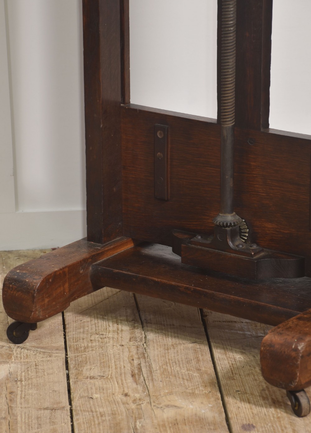 A nineteenth-century dark oak artist studio easel featuring a winding crank handle mechanism and castors on the base. View VII