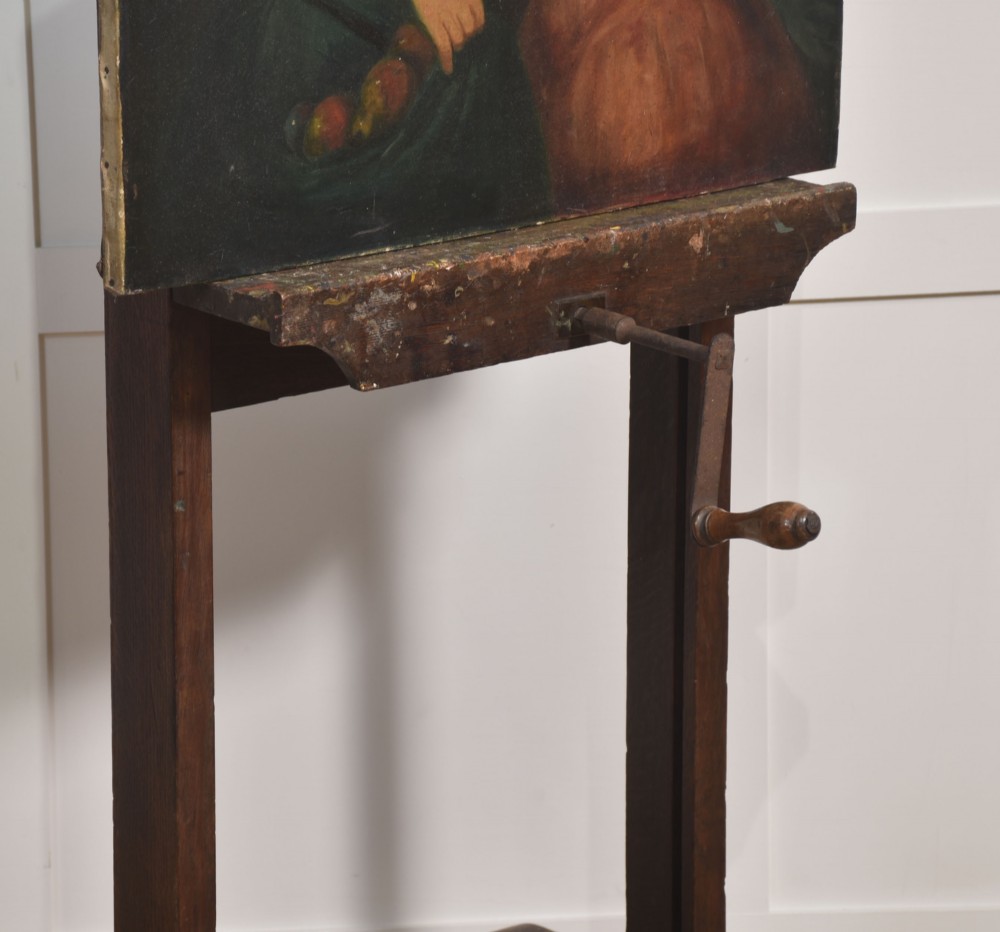 A nineteenth-century dark oak artist studio easel featuring a winding crank handle mechanism and castors on the base. View XII