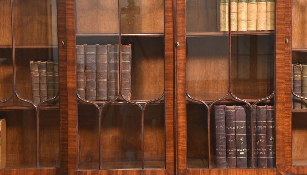 A large Regency Revival flame mahogany breakfront library bookcase with astragal glazed upper doors and panelled cupboard base. View III